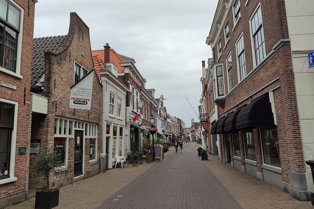 Smalle historische winkelstraat met oude gevels en winkelpuien in het centrum van Voorburg